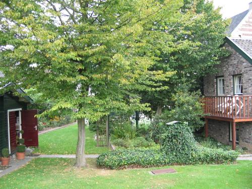 a house with a tree in front of a yard at Hotel De Oude Brouwerij in Mechelen
