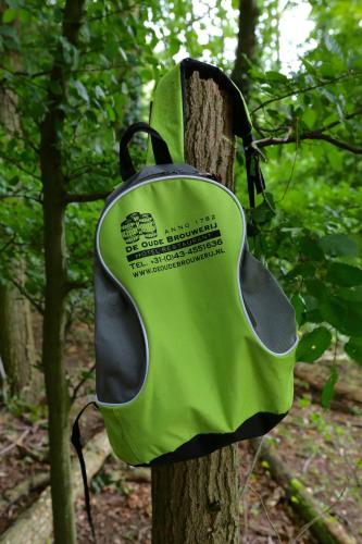 a green bag hanging on a tree in the woods at Hotel De Oude Brouwerij in Mechelen