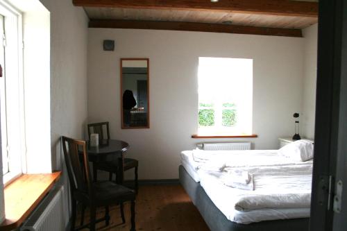a bedroom with a bed and a table and a chair at Hoby Gård in Borrby