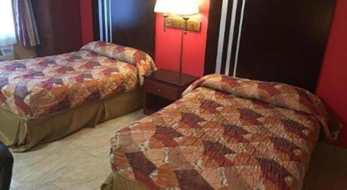 a hotel room with two beds and a lamp at Travelodge by Wyndham Bay Shore Long Island in Bay Shore