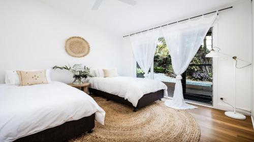 a bedroom with two beds and a window at Illuka Byron - 124 Coopers Shoot Road in Coopers Shoot