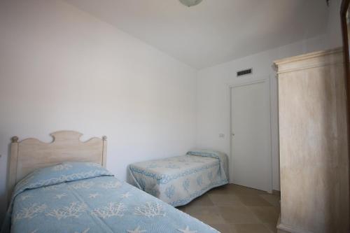 a small bedroom with a bed and a stool at Le 9 Gocce Seaview Apartment in Palau