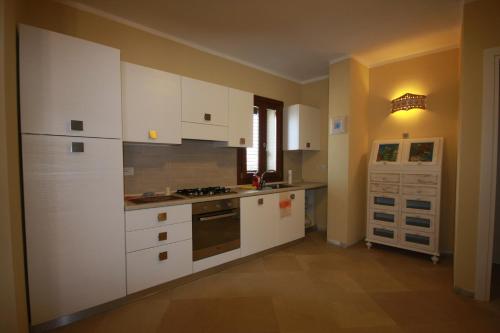 een keuken met witte kasten en een fornuis met oven bij Le 9 Gocce Seaview Apartment in Palau
