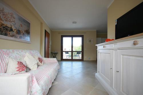 a living room with a couch and a flat screen tv at Le 9 Gocce Seaview Apartment in Palau