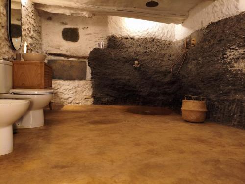 a bathroom with a toilet and a sink at Santuario Atalbéitaca Five Senses in Atalbéitar