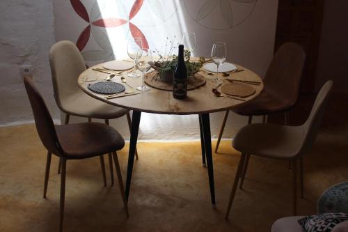 a table with glasses and a bottle of wine on it at Santuario Atalbéitaca Five Senses in Atalbéitar