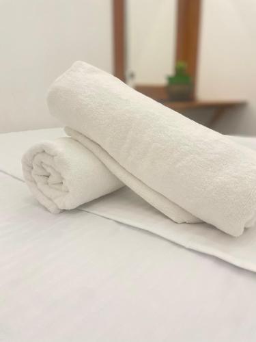 a roll of white towels sitting on top of a bed at Villa Senu in Ambalangoda
