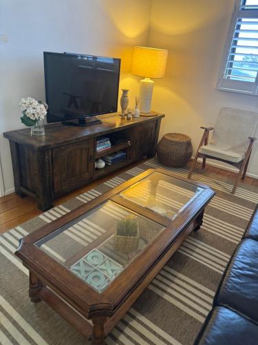 a living room with a tv and a coffee table at Urbane on William in Rockhampton