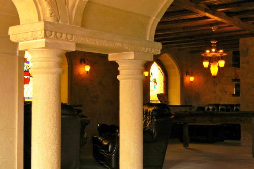 Cette-EygunにあるAuberge Toison d'Orの柱とテーブル、ステンドグラスの窓が備わるお部屋