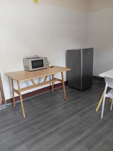 Elle comprend un four micro-ondes installé sur une table et un réfrigérateur. dans l'établissement Backpack Bay, à Nathon Bay