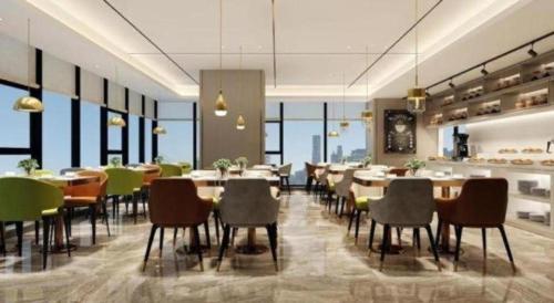 a dining room with tables and chairs and windows at GreenTree Alliance Hotel Chongqing Qianjiang County Wuling Shui'an Jiaotong Xi Road in Qianjiang