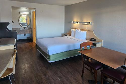 a hotel room with a bed and a table at Rodeway Inn & Suites Thousand Palms - Rancho Mirage in Thousand Palms