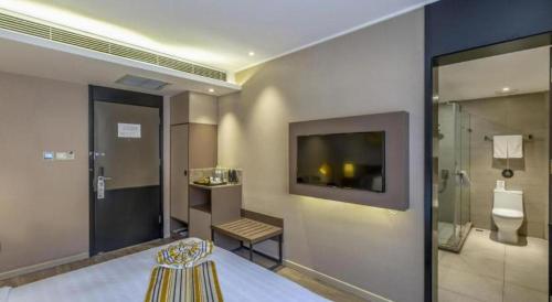 a room with a bathroom with a toilet and a television at Yitel Tai'an Taishan Hongmen Daimiao in Tai'an