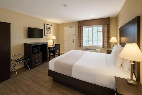 a hotel room with a large bed and a desk at Rodeway Inn El Cajon - San Diego East in El Cajon