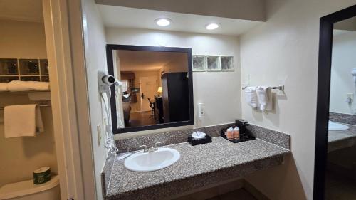 a bathroom with a sink and a large mirror at Rodeway Inn El Cajon - San Diego East in El Cajon