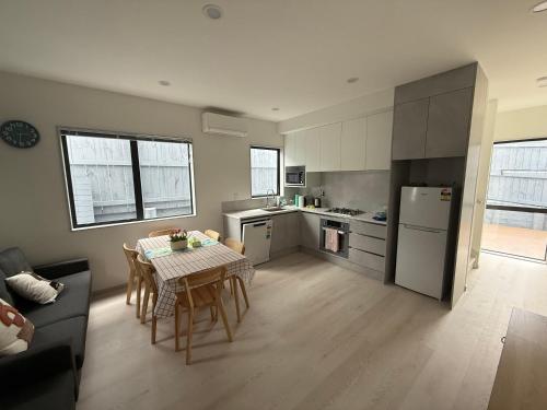 a living room with a table and a kitchen at 14C grove lane pakuranga in Auckland