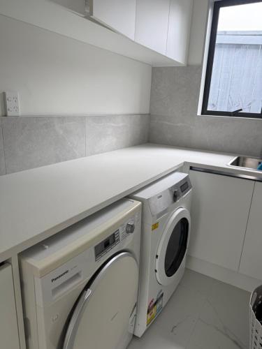 a laundry room with a washer and dryer in it at 14C grove lane pakuranga in Auckland