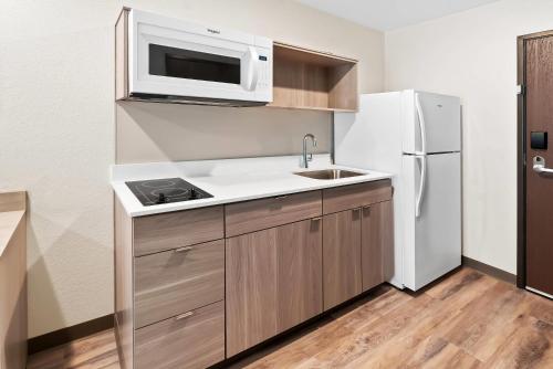 a kitchen with a white refrigerator and a microwave at WoodSpring Suites Greenville Airport in Greenville