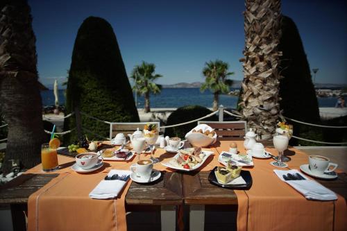 einen Tisch mit Nahrung und dem Meer im Hintergrund in der Unterkunft Valis Resort Hotel in Volos