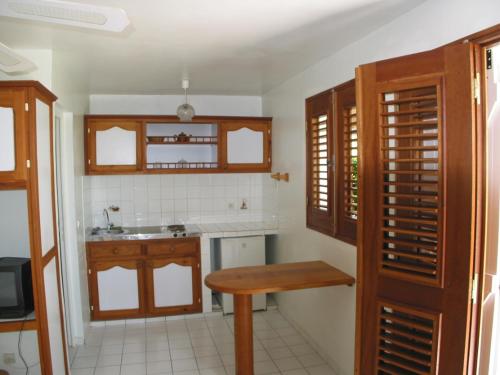 a kitchen with a wooden table and a sink at Meridienne Creole in Sainte-Anne