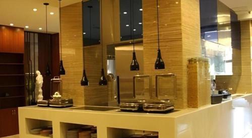 a kitchen with a counter in a room with lights at Grand Skylight Hotel KaiMei in Nanchang