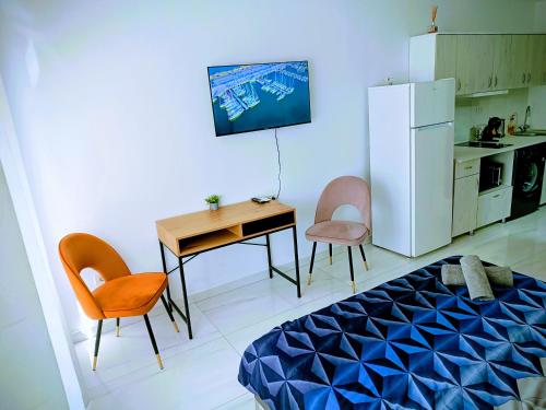 a room with a bed and a table and a refrigerator at Relax Apartament in Arad