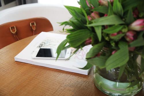 a vase of flowers sitting on a table with a book at Ofelias Hotel 4Sup in Barcelona