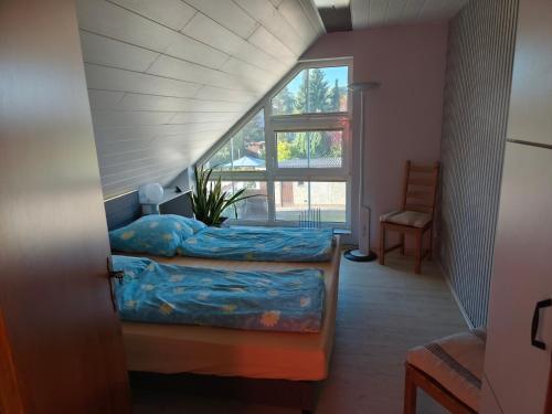 a attic room with two beds and a window at Krämer-Bude in Oberkrämer