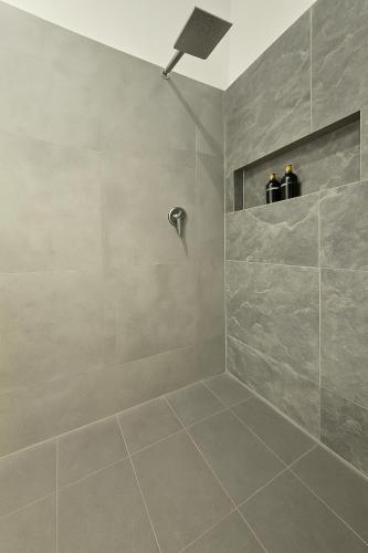 a bathroom with a shower with two bottles at Solara Beach House in Tangalle