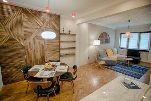 Luxury and stylish apartment in the heart of the city في صوفيا: غرفة معيشة مع طاولة وأريكة