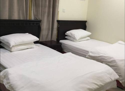 Ένα ή περισσότερα κρεβάτια σε δωμάτιο στο أرض الذهب للشقق المخدومة الرويضة