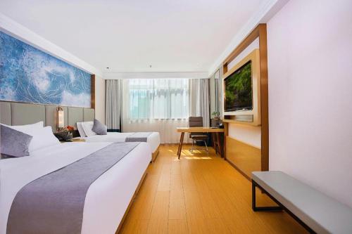 a hotel room with two beds and a desk at GreenTree Inn Taiyuan PinGYAng Road Business Hotel in Taiyuan