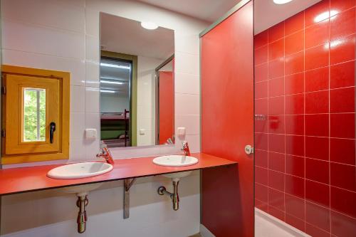 Baño con 2 lavabos y espejo en Alberg La Sala, en La Pobla de Lillet