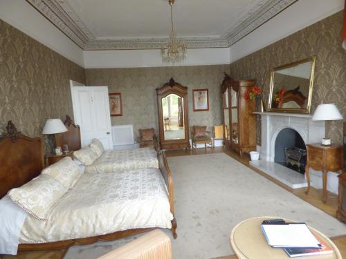 a large bedroom with a bed and a fireplace at Moorlands in Helensburgh