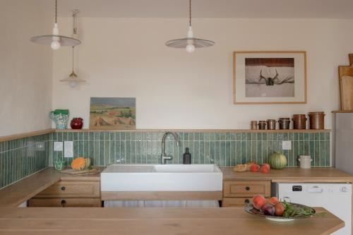 una cucina con lavandino e cesto di frutta di Le Petit Civry a Saint-Julien-de-Civry