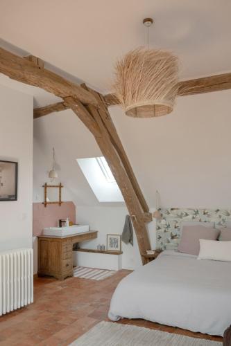 a bedroom with a bed and a desk in a room at Le Petit Civry in Saint-Julien-de-Civry
