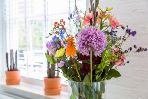 a vase filled with colorful flowers on a window sill at Bij Jans in Hilvarenbeek