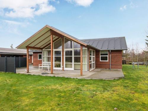 a small house with a large porch and a deck at 8 person holiday home in Glesborg in Glesborg