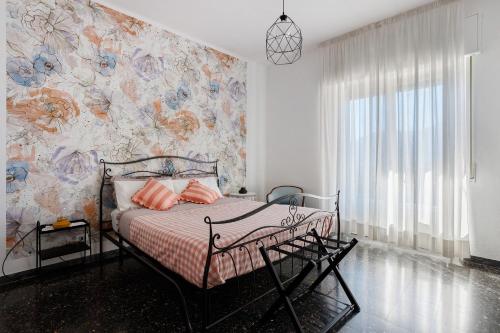 a bedroom with a bed with a floral wall at Ca' Montello Apartment in La Spezia