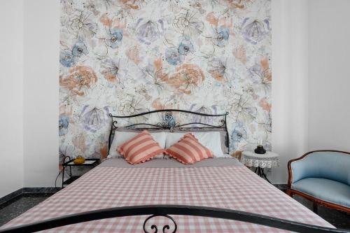 a bedroom with a bed with a floral wallpaper at Ca' Montello Apartment in La Spezia