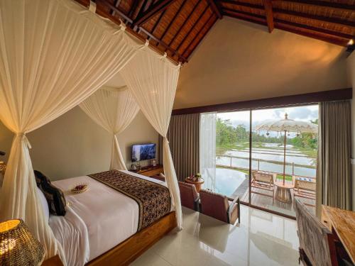 Un dormitorio con una cama con dosel y un balcón. en Ascarya Ubud, en Ubud