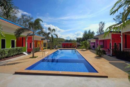 a swimming pool in front of some houses at At night Airport Resort in Patong Beach