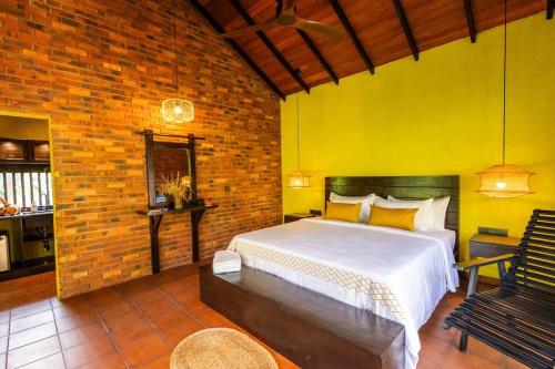 une chambre avec un lit et un mur de briques dans l'établissement Cinnamon Cottage Near Colombo Intl Airport, à Madampella Ihala