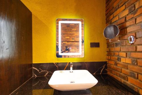 une salle de bain jaune avec un lavabo et une fenêtre dans l'établissement Cinnamon Cottage Near Colombo Intl Airport, à Madampella Ihala