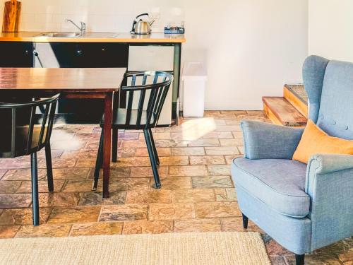 ein Wohnzimmer mit Tisch und Stühlen und eine Küche in der Unterkunft Clonmara Country House and Cottages in Port Fairy