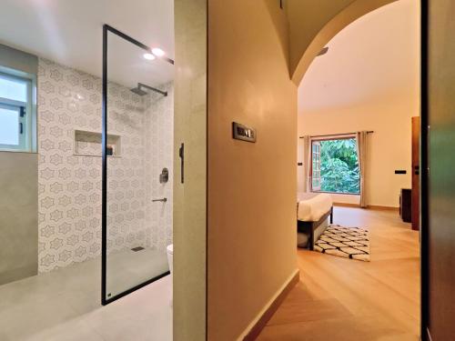 a bathroom with a shower and a glass door at Villa Laz, Parra close to calangute- Pool,Jacuzzi,Cook in Parra