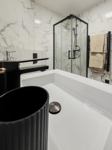 a white bathroom with a shower and a tub at L'ombelle - Studio vert d'eau avec petit extérieur in Darnétal