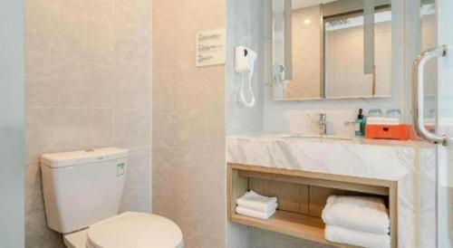 a bathroom with a toilet and a sink and a mirror at Holiday Inn Express Lhasa Potala Square By IHG in Lhasa