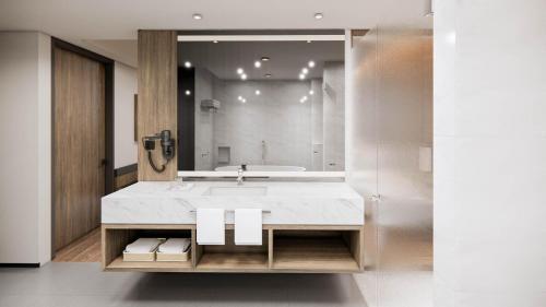 a bathroom with a sink and a large mirror at Oakwood Yogyakarta in Jetis