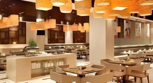 a restaurant with tables and chairs and lights at Ramada Plaza by Wyndham Chuzhou in Chuzhou